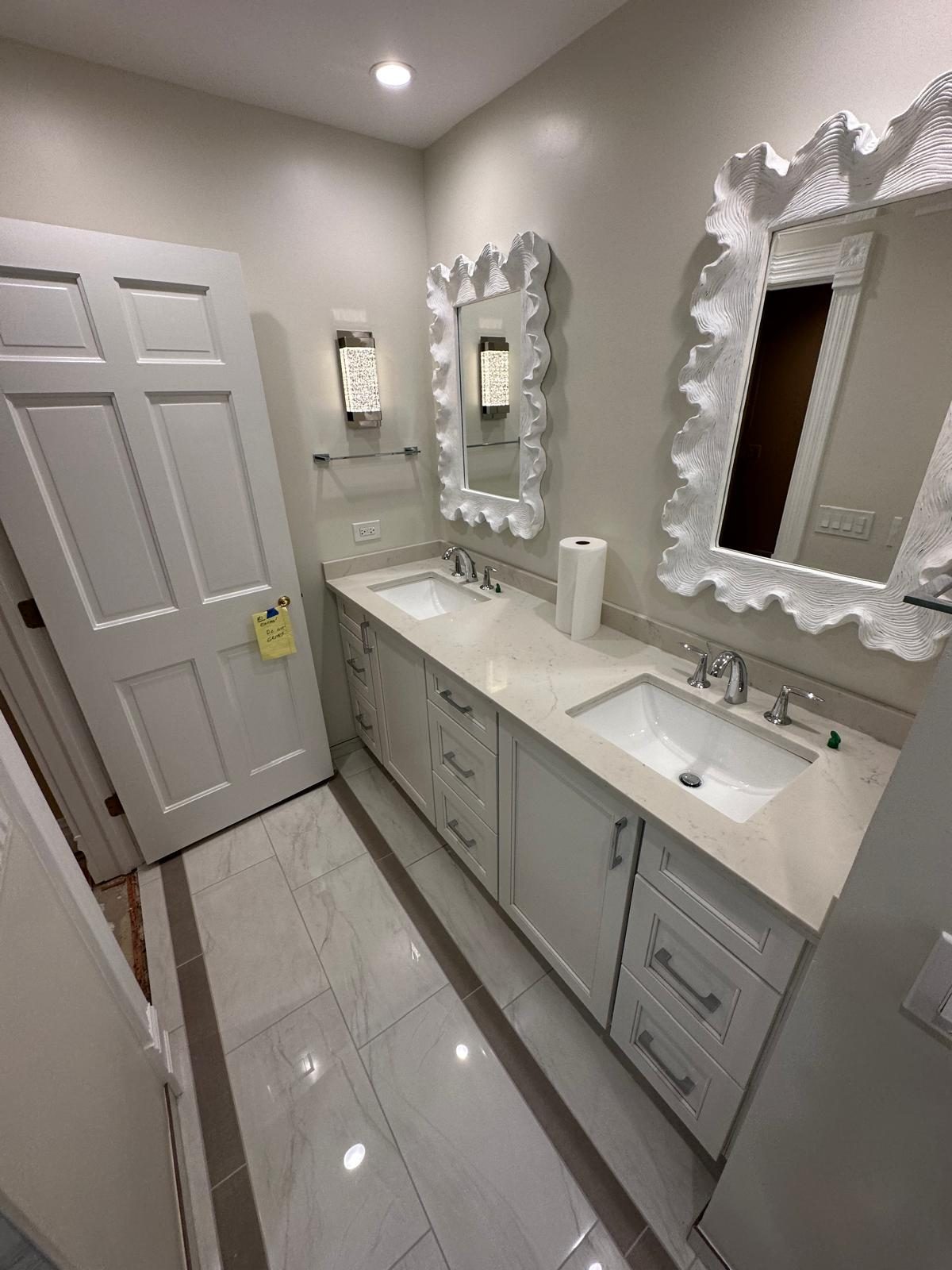 Double vanity with two undermount sinks, white cabinets and decorative mirrors